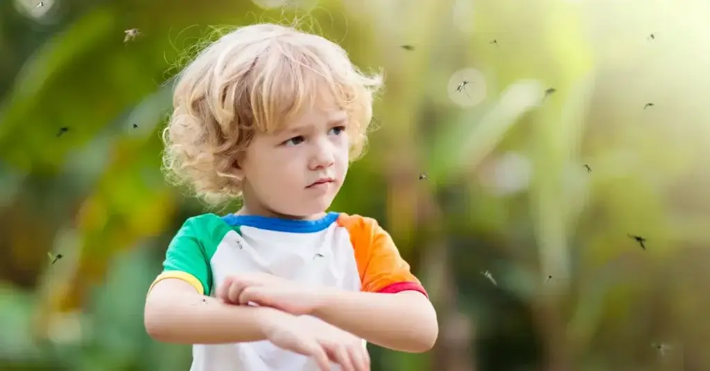 A child itching his arms after being bitten by mosquitoes at a non bug-free backyard party.