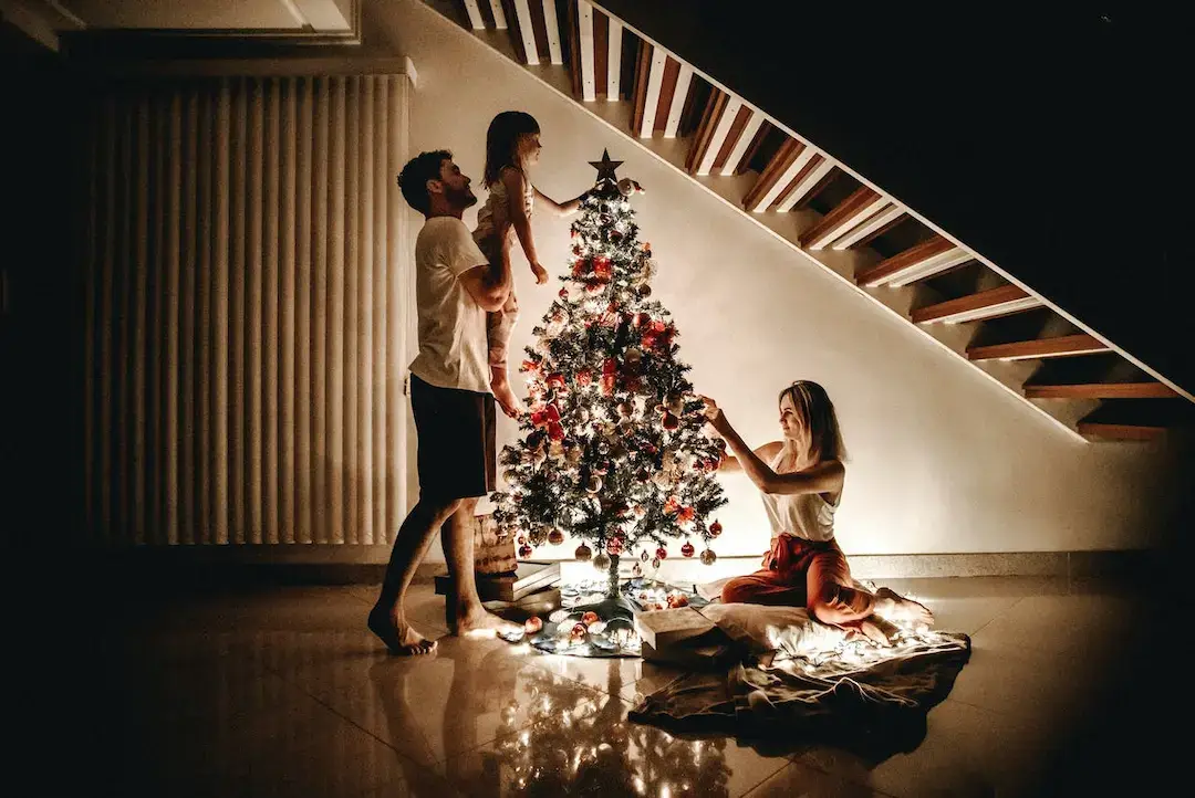 Family decorating a tree with a home protected by an indoor pest control plan.