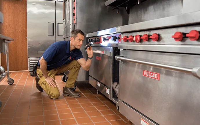 Male pest control professional inspects commercial kitchen. Pest control in Mooresville NC.