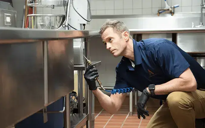 Man inspecting a commercial kitchen, highlighting the need for commercial pest control in Hickory, NC.